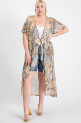 Plus size woman in paisley print kimono cover-up with tie waist, styled over denim shorts and heels