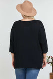 Black plus size waffle knit top with 3/4 sleeves, back view, paired with jeans and a tan hat