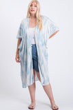 Plus size woman wearing blue and white tie-dye kimono over white top and denim shorts