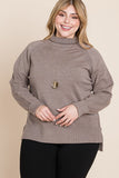 Plus size woman in cozy taupe turtleneck sweater with ribbed details, styled with black pants and gold necklace